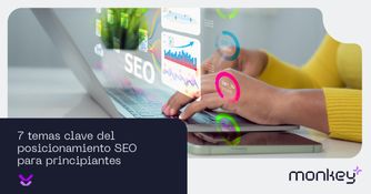7 temas clave del posicionamiento SEO para principiantes Persona escribiendo en laptop con gráficos digitales relacionados con SEO