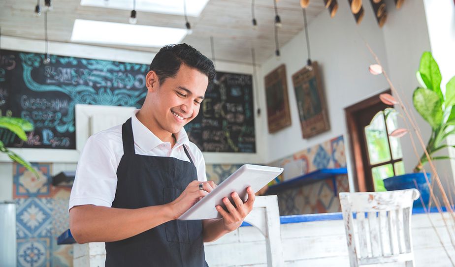 Dueño de negocio utilizando tablet para gestión digital