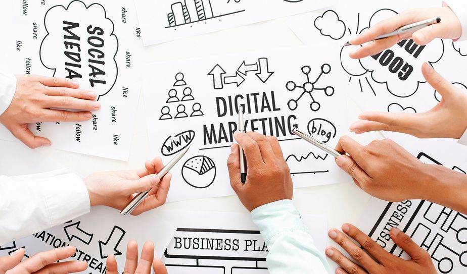 Planeación de campañas con equipo de marketing digital Manos colaborando sobre esquemas de marketing digital